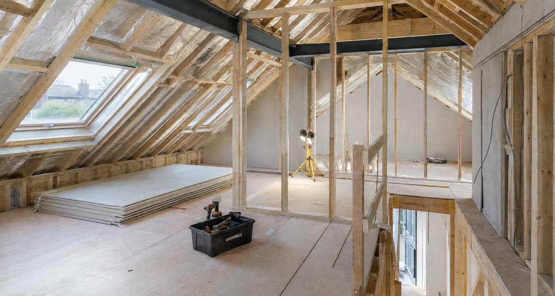 Loft conversion mid-build — steels in, studwork up, roof windows fitted